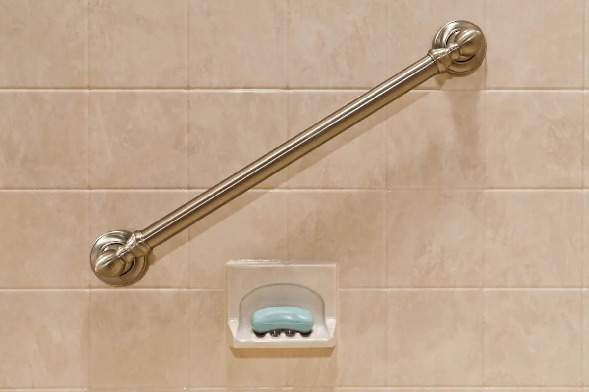 Brushed nickel angled grab bar on travertine wall for safety