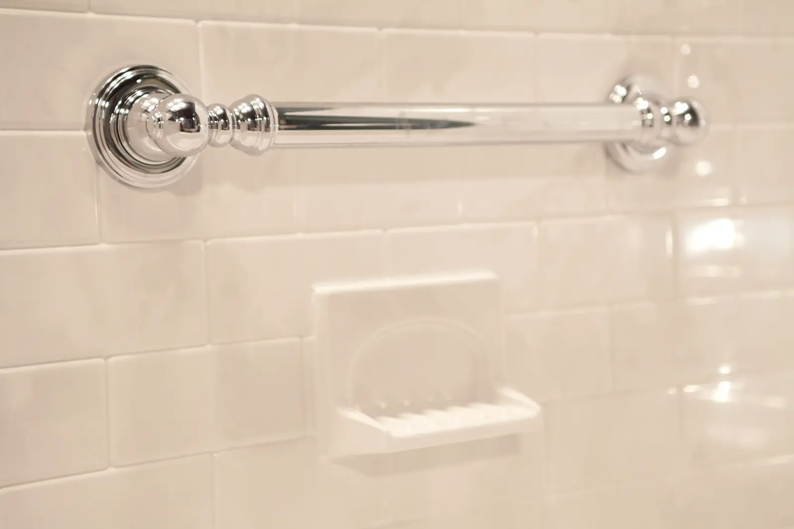Chrome grab bar installed on subway tile for bathroom safety