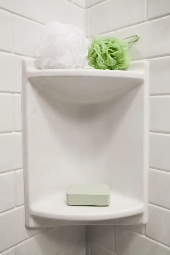 Two-shelf corner caddy with white subway tile walls